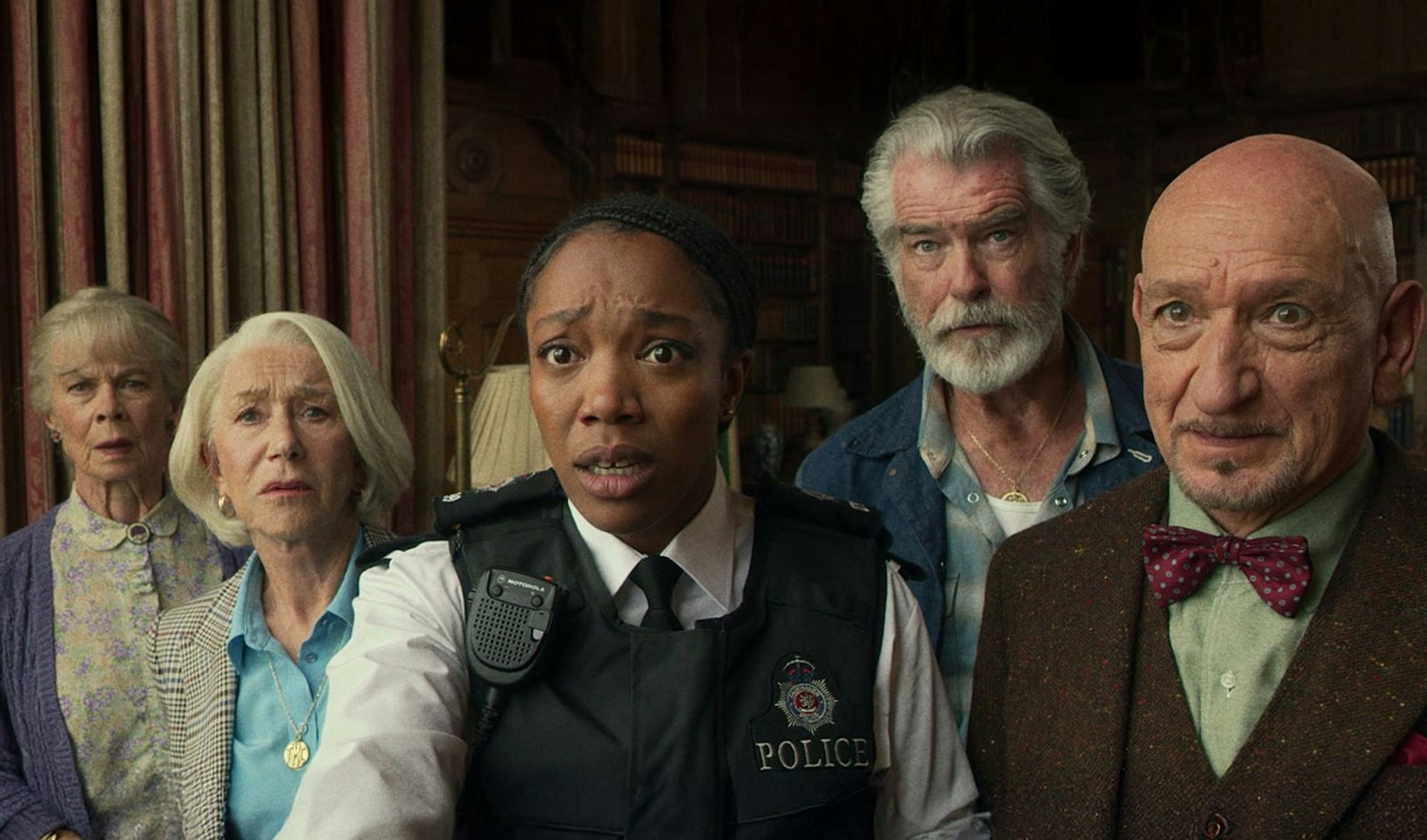 Joyce (Celia Imrie, links), Elizabeth (Helen Mirren, zweite von links), Ron (Pierce Brosnan, zweiter von rechts) und Ibrahim (Ben Kingsley) bringen sich und Polizistin Donna (Naomi Ackie) immer wieder in die Zwickmühle. (Bild: Giles Keyte/Netflix)