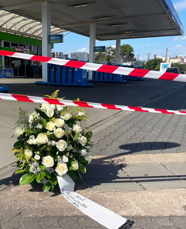 An der Tankstelle, an der nach einem Überfall ein Polizist getötet wurde, haben Mitarbeiter einen Kranz niedergelegt.