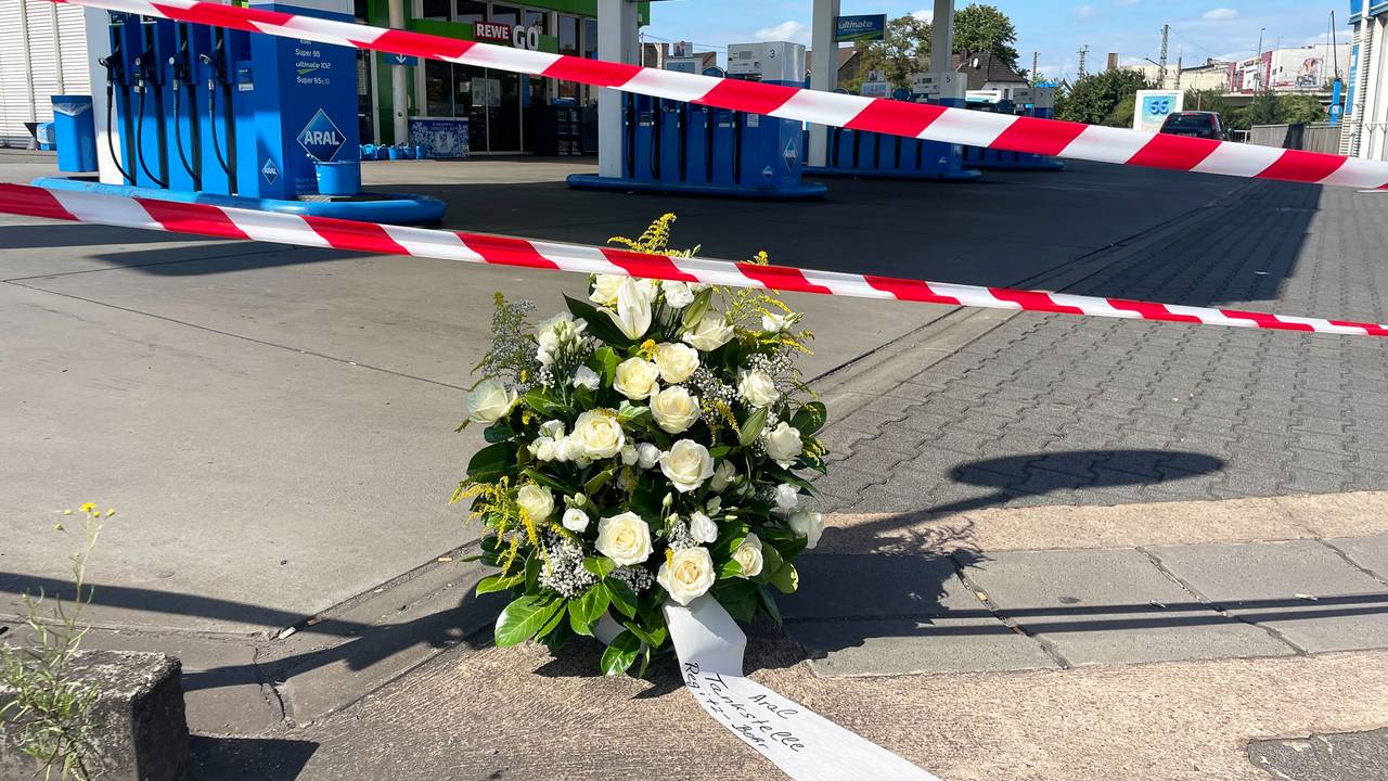 An der Tankstelle, an der nach einem Überfall ein Polizist getötet wurde, haben Mitarbeiter einen Kranz niedergelegt.