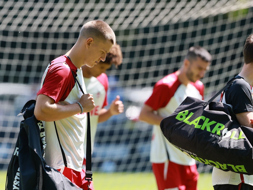 Florian Dietz trägt nach dem FC-Training den Ballsack.