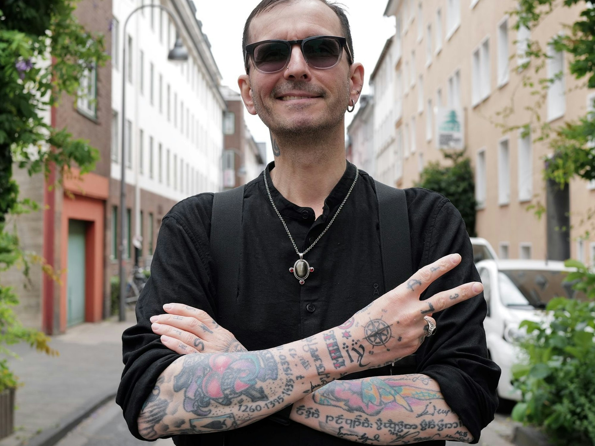 Der Kriminalbiologe Mark Benecke hat seine Arme, die voll mit Tätowierungen sind, vor dem Oberkörper verschränkt.