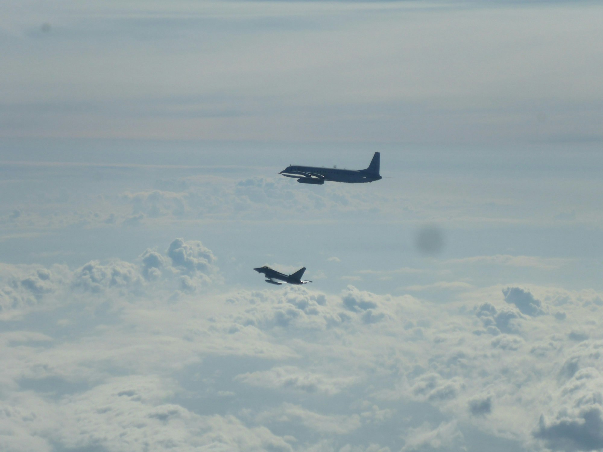 Ein Eurofighter (unten) und ein russisches Flugzeug fliegen über der Ostsee. Die Nato hat wegen des Anflugs eines russischen Aufklärungsflugzeugs über der Ostsee zwei deutsche Eurofighter alarmiert.