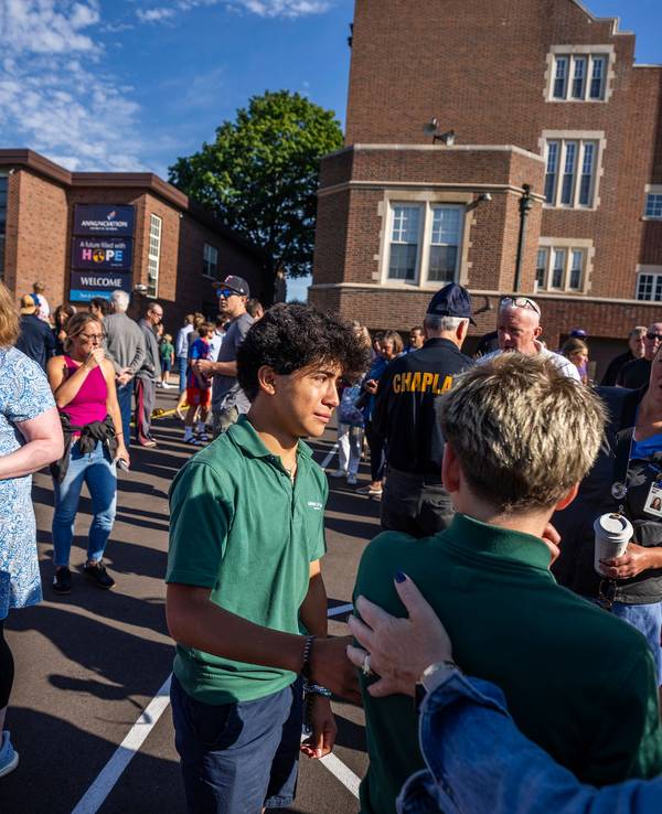 Schüler und Eltern warten vor einem Schulgebäude in Minneapolis. Bei den tödlichen Schüssen an einer Schule geht die Polizei von einem einzelnen Schützen aus.