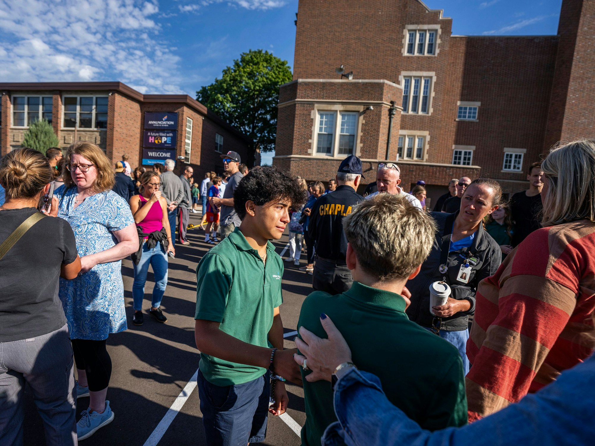 Schüler und Eltern warten vor einem Schulgebäude in Minneapolis. Bei den tödlichen Schüssen an einer Schule geht die Polizei von einem einzelnen Schützen aus.