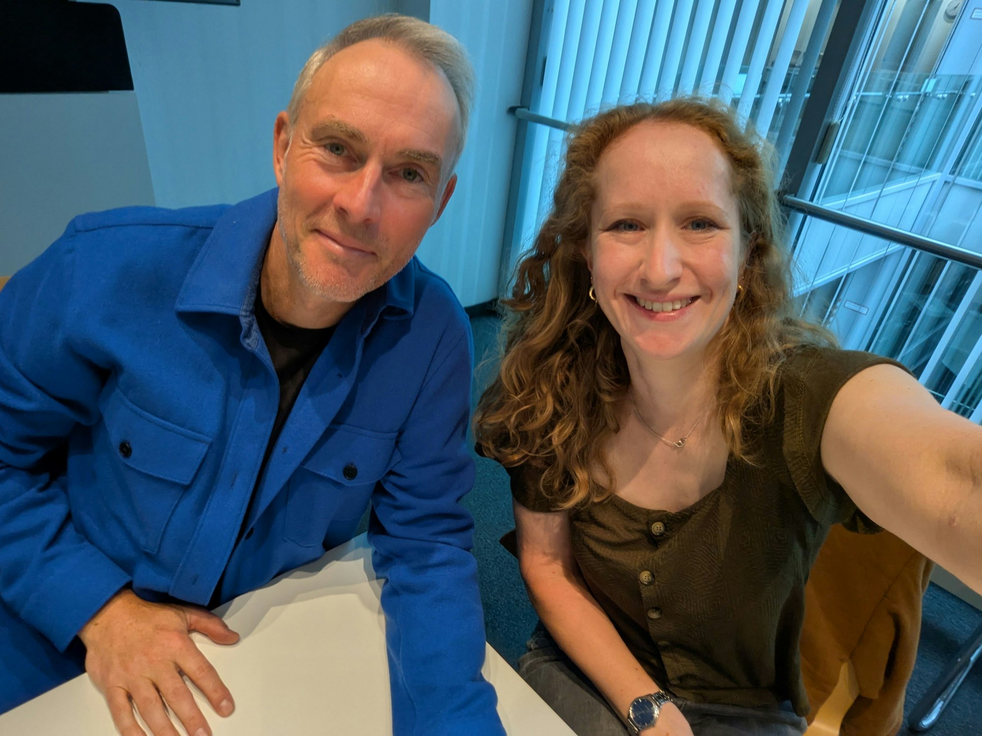 Ein Mann und eine Frau lachen bei einem Selfie fröhlich in die Kamera.