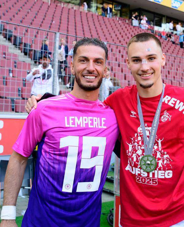 Leart Pacarada legt seinen Arm um Tim Lemperle und trägt dabei ein DFB-Trikot mit Lemperle-Flock falschherum.