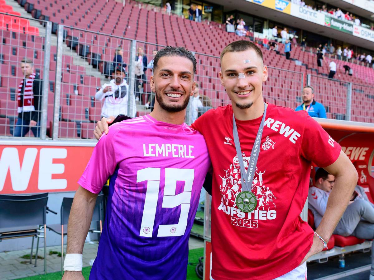 Leart Pacarada legt seinen Arm um Tim Lemperle und trägt dabei ein DFB-Trikot mit Lemperle-Flock falschherum.