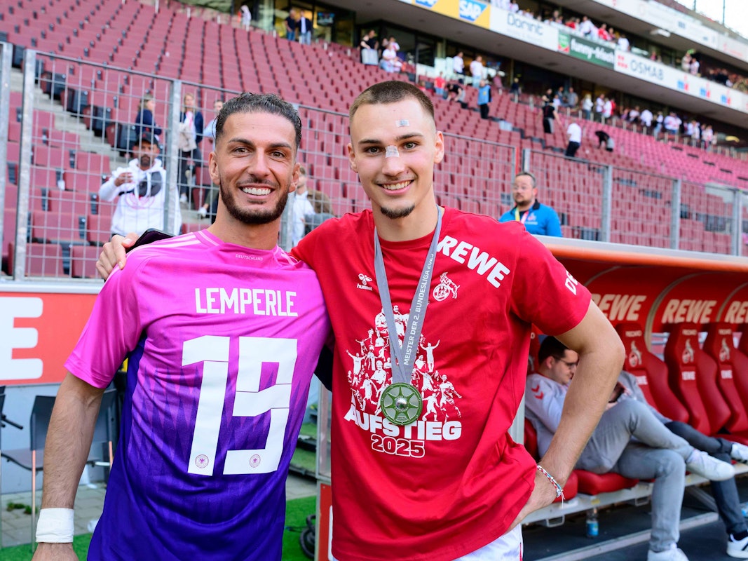 Leart Pacarada legt seinen Arm um Tim Lemperle und trägt dabei ein DFB-Trikot mit Lemperle-Flock falschherum.