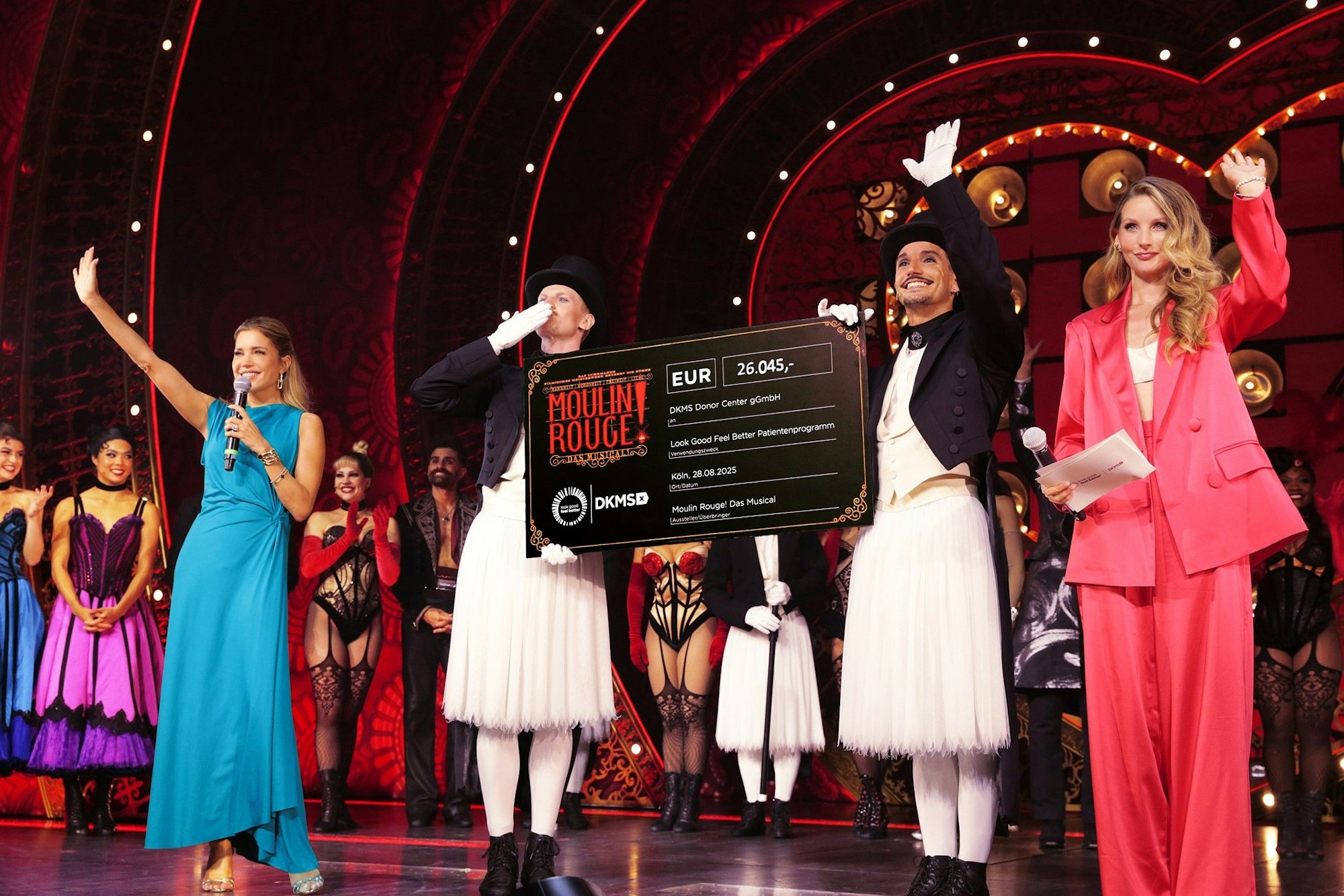 Sylvie Meis (l.), Anna Hiltrop (r.) und der Cast von Moulin Rouge bei der Scheckübergabe.