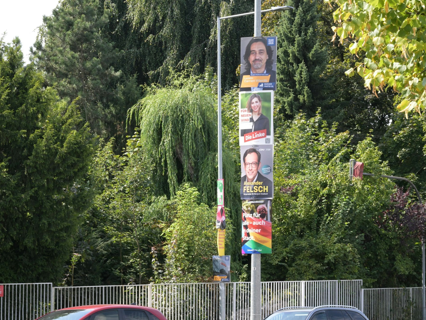 Vier Wahlplakate hängen direkt übereinander an einem Mast.
