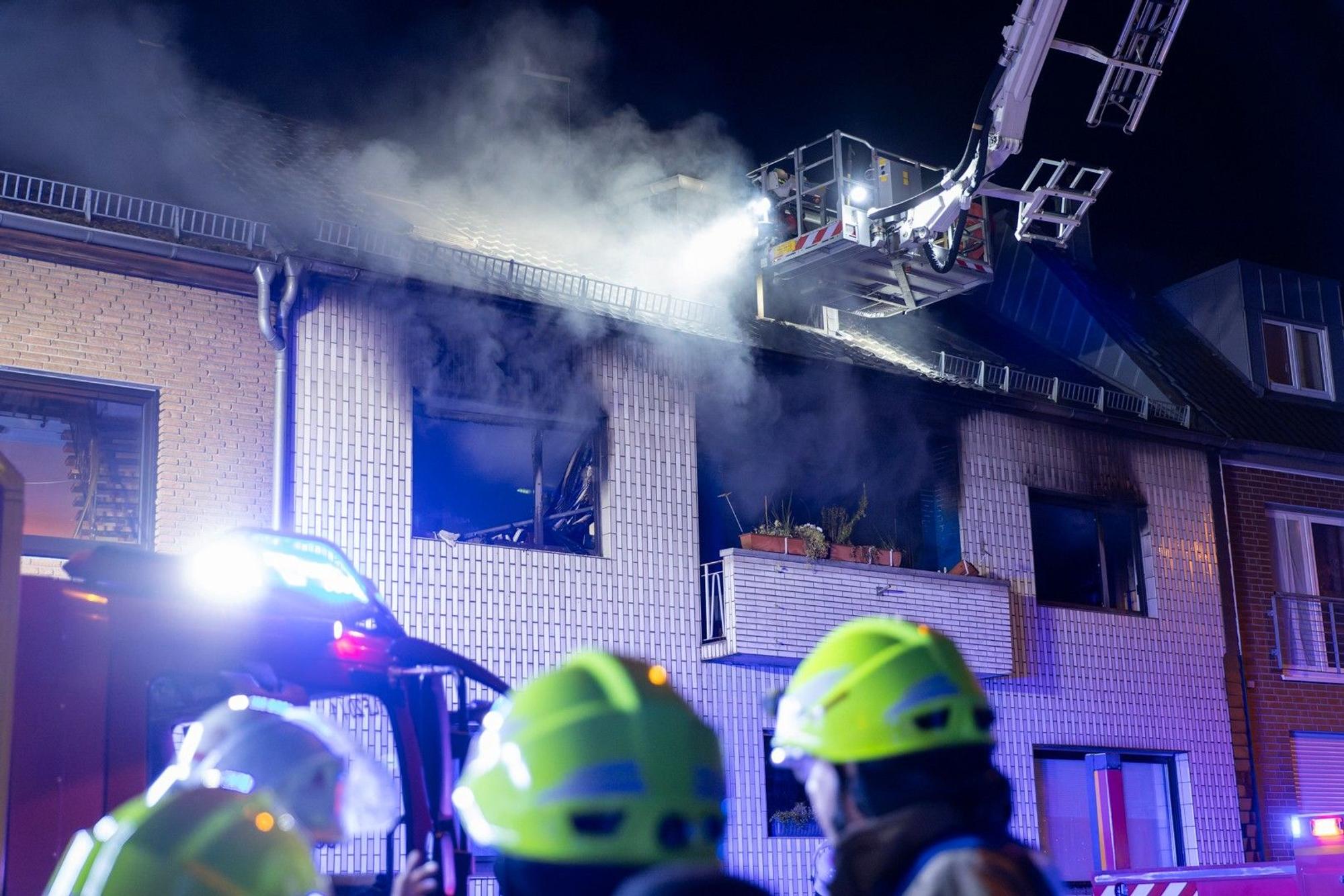 Kräfte der Feuerwehr löschen einen Brand im ersten Stock eines Wohnhauses in Frechen. Als die Retter am Einsatzort antrafen, schlugen bereits Flammen aus den Fenstern. Drei Menschen wurden verletzt.