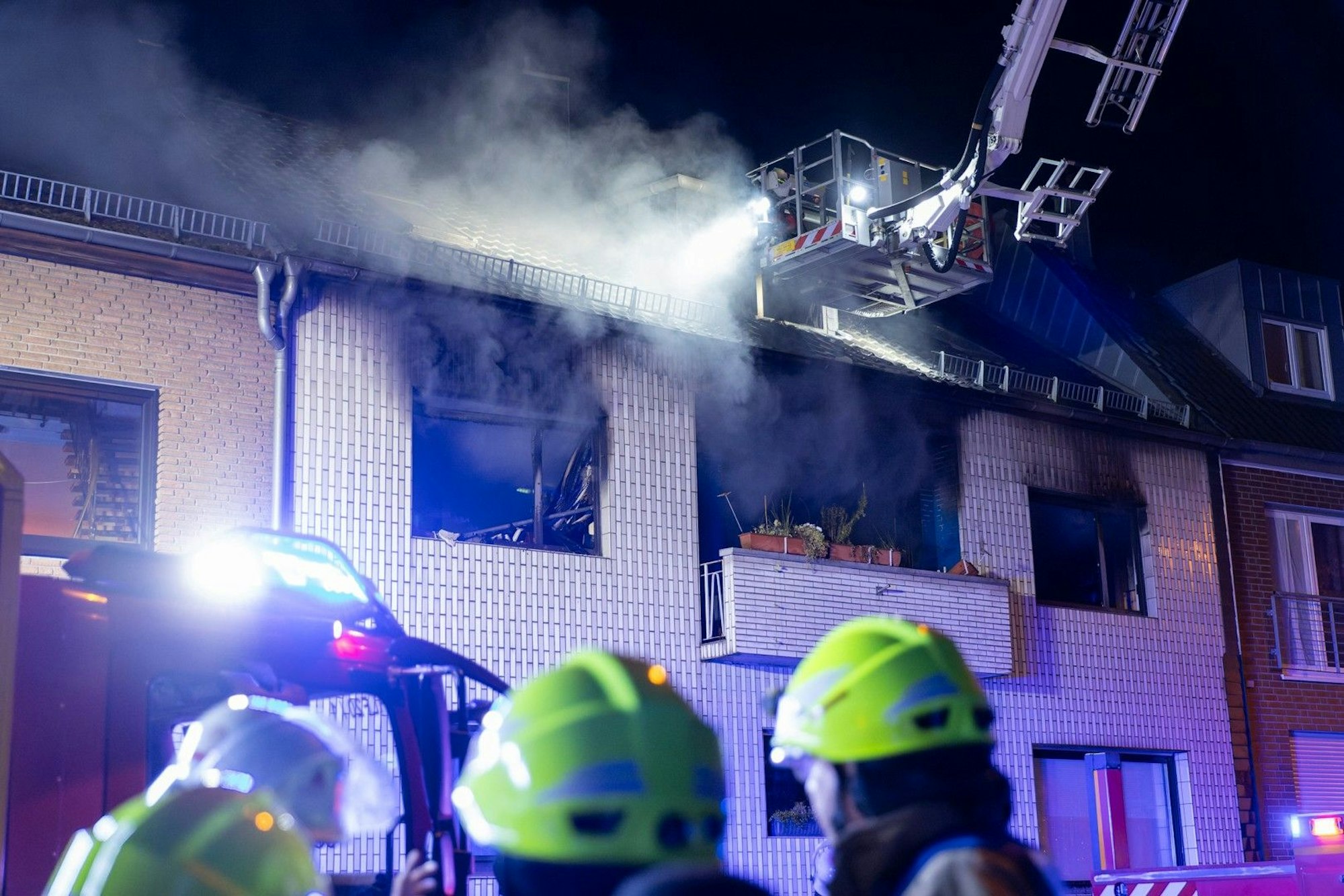 Kräfte der Feuerwehr löschen einen Brand im ersten Stock eines Wohnhauses in Frechen. Als die Retter am Einsatzort antrafen, schlugen bereits Flammen aus den Fenstern. Drei Menschen wurden verletzt.