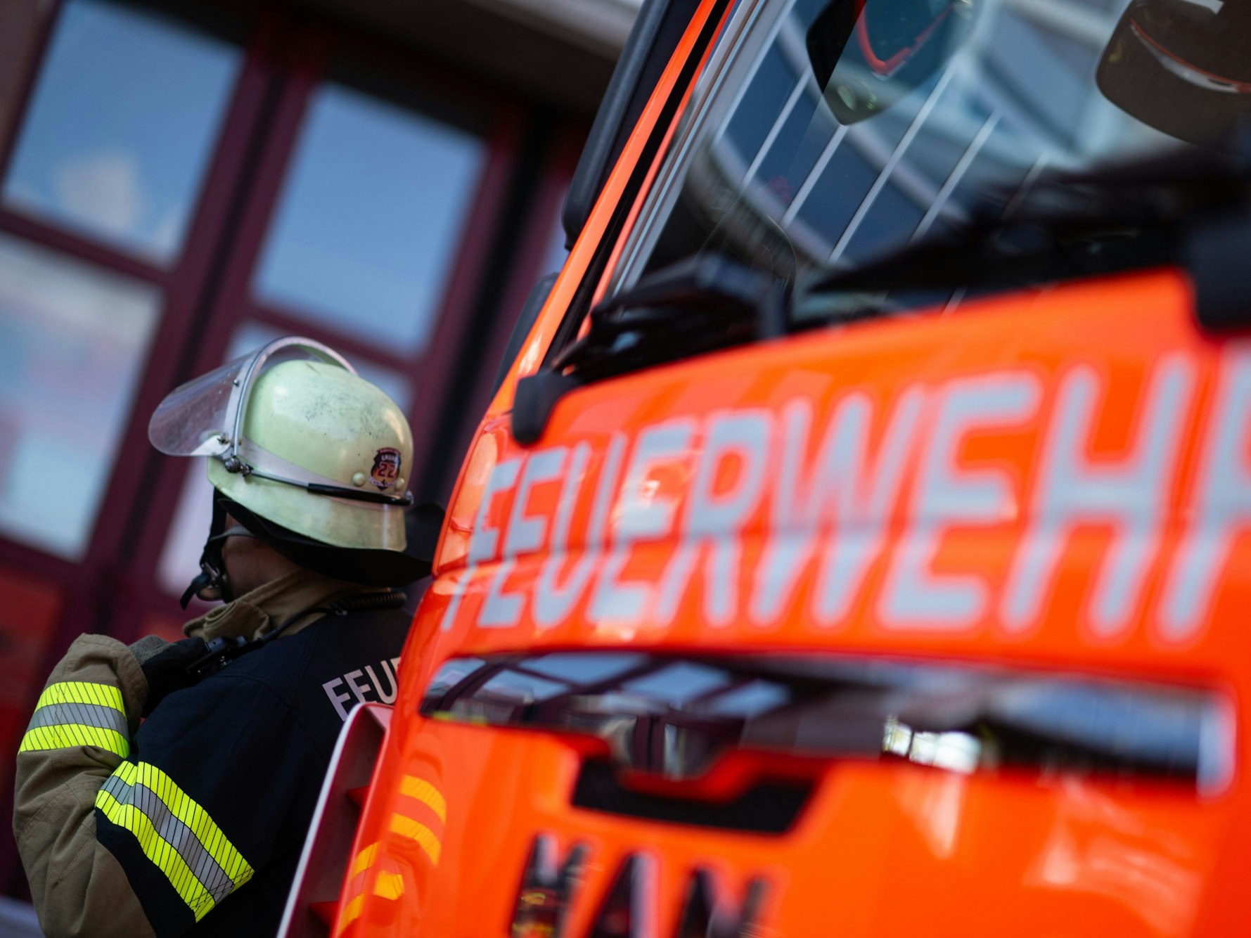 Eine Einsatzkraft steht neben einem Einsatzfahrzeug der Feuerwehr. (Symbolfoto)