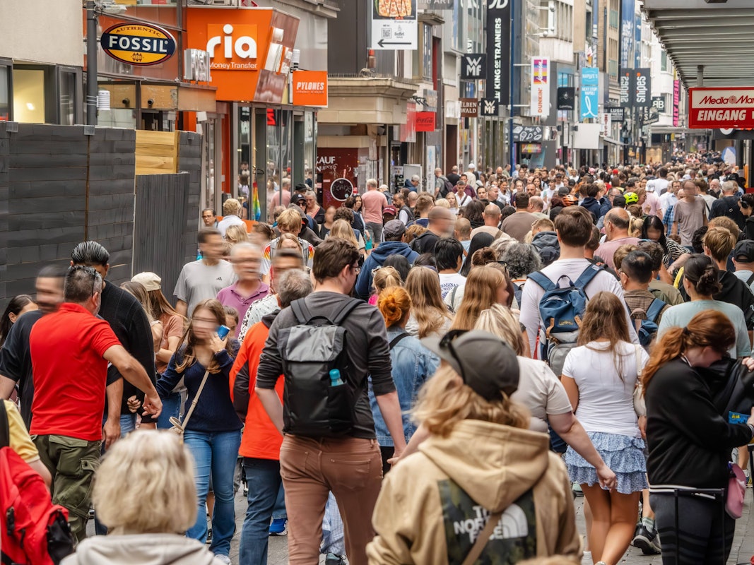 Menschenmassen schieben sich durch eine Einkaufsstraße.