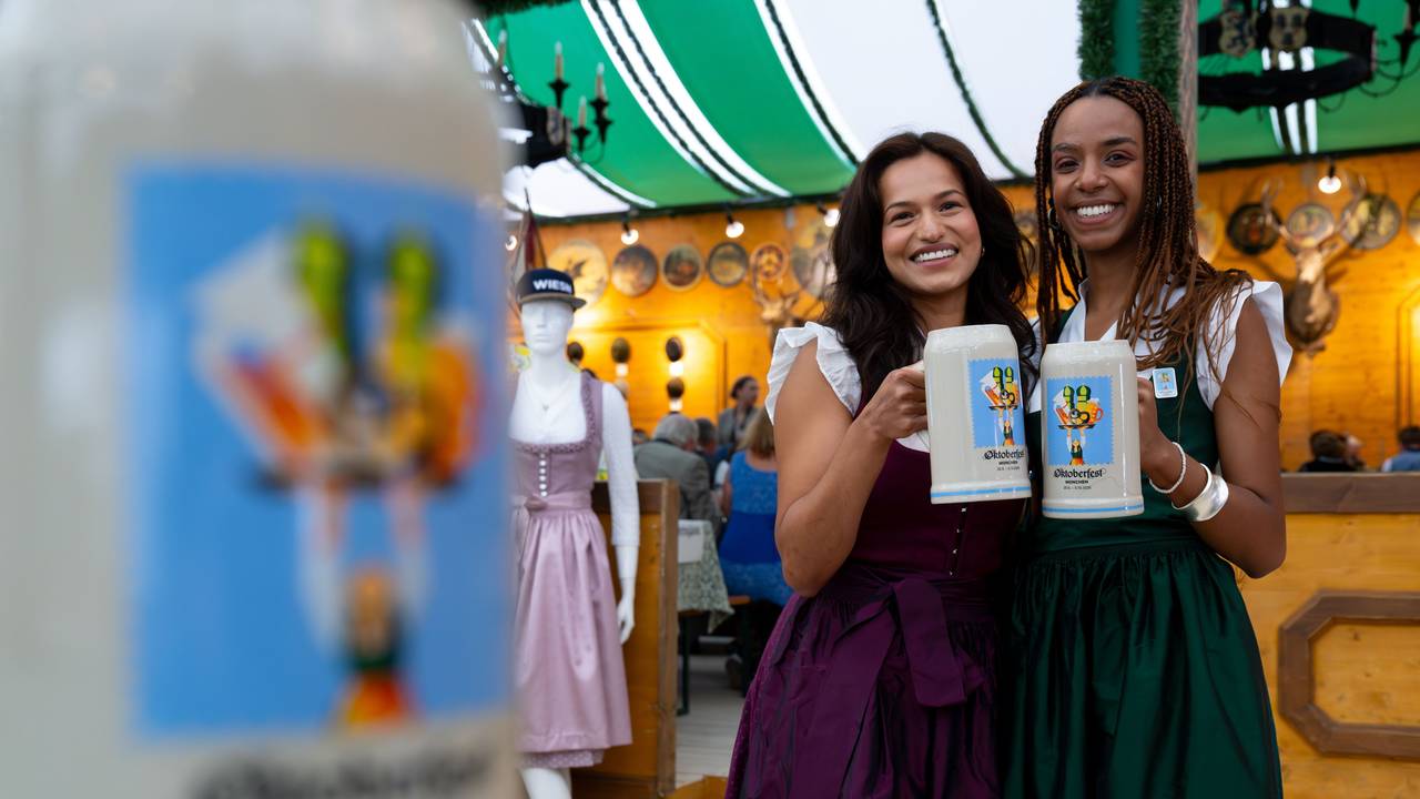 Amiera Harithas (l) und Dinah-Charles Francis, Designerinnen des Motivs vom offiziellen Wiesn-Maßkrug 2025. Das 190. Oktoberfest findet vom 20. September bis 5. Oktober 2025 auf der Münchner Theresienwiese statt.