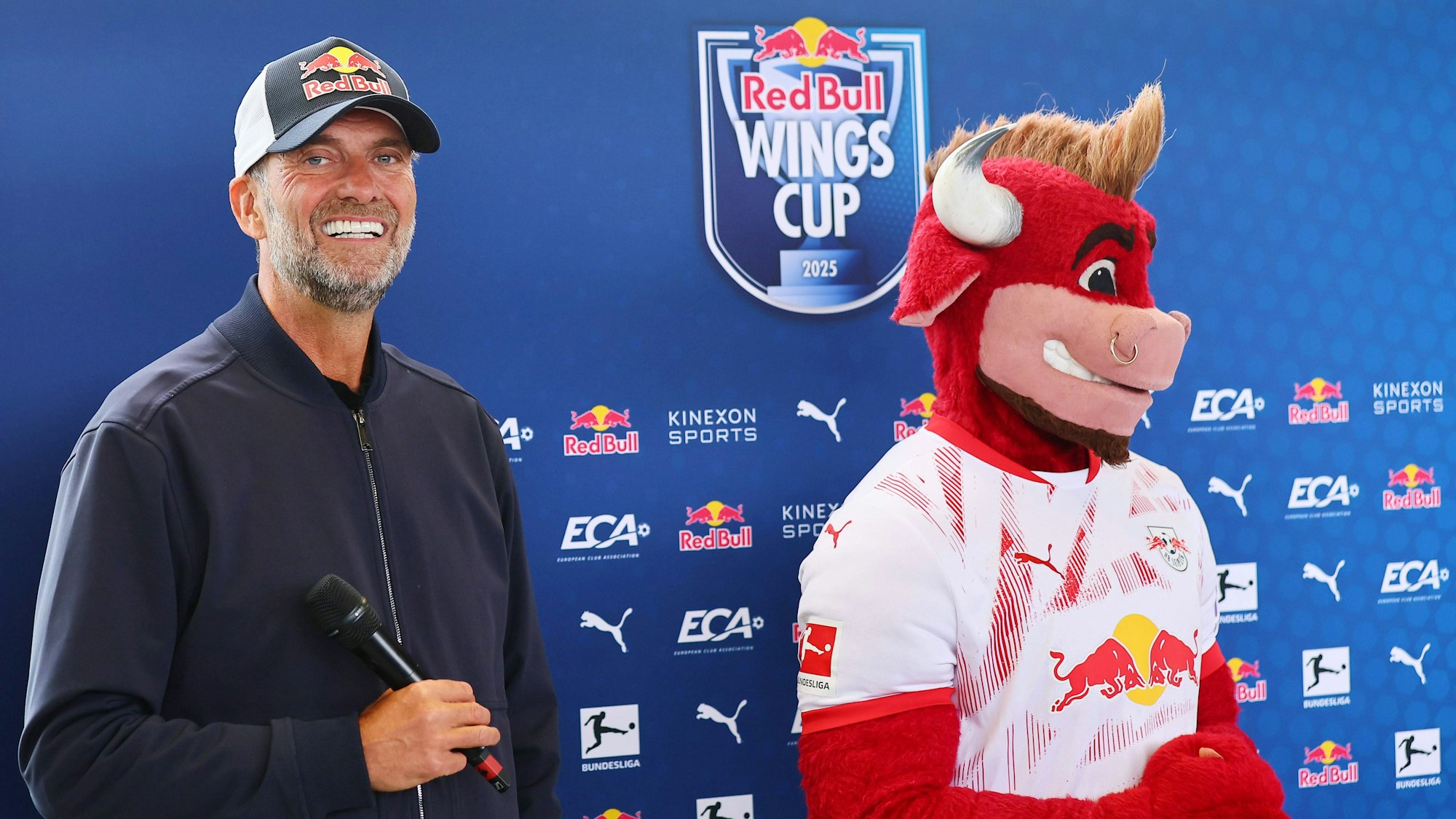 Jürgen Klopp steht neben Bulli, dem Maskottchen von RB Leipzig.