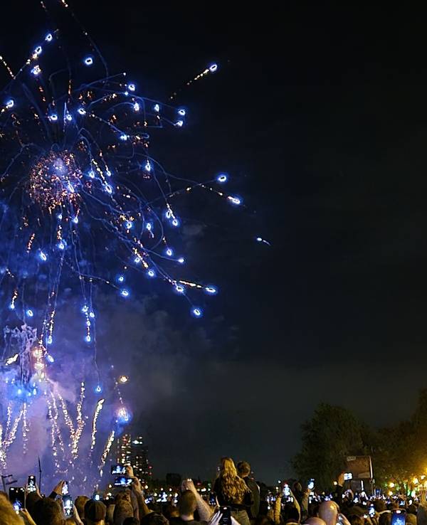 Besucher sehen sich ein Feuerwerk an. Das Festival Kölner Lichter mit Musik und Feuerwerk am Rhein.