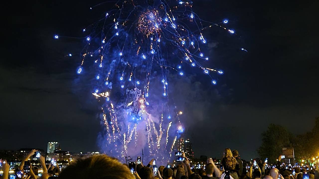 Besucher sehen sich ein Feuerwerk an. Das Festival Kölner Lichter mit Musik und Feuerwerk am Rhein.