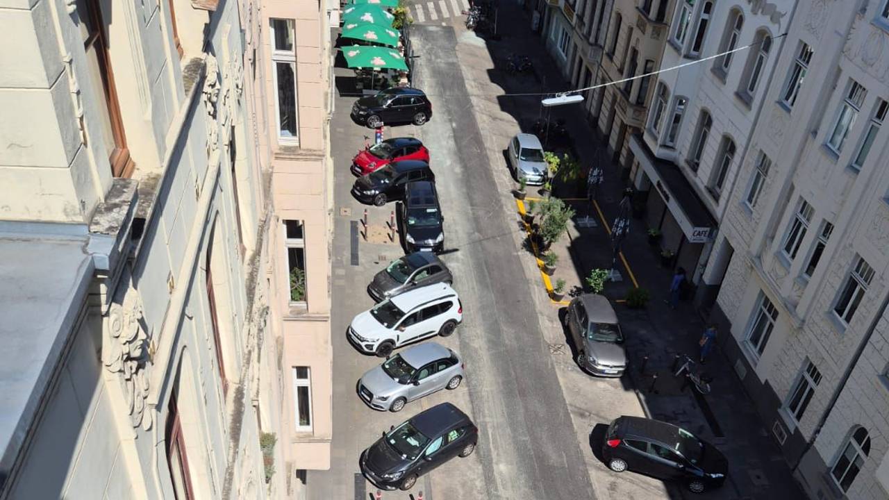 Autos parken quer in einer Straße.