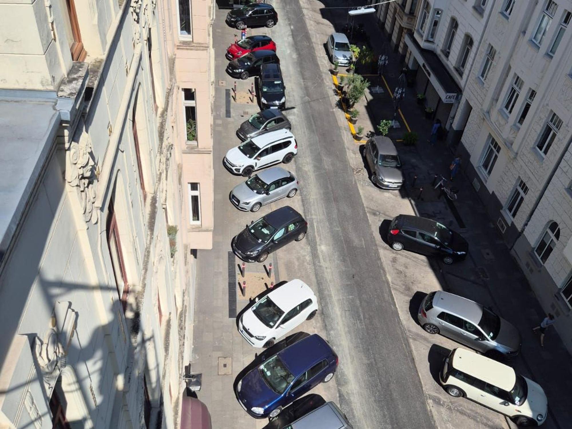 Autos parken quer in einer Straße.