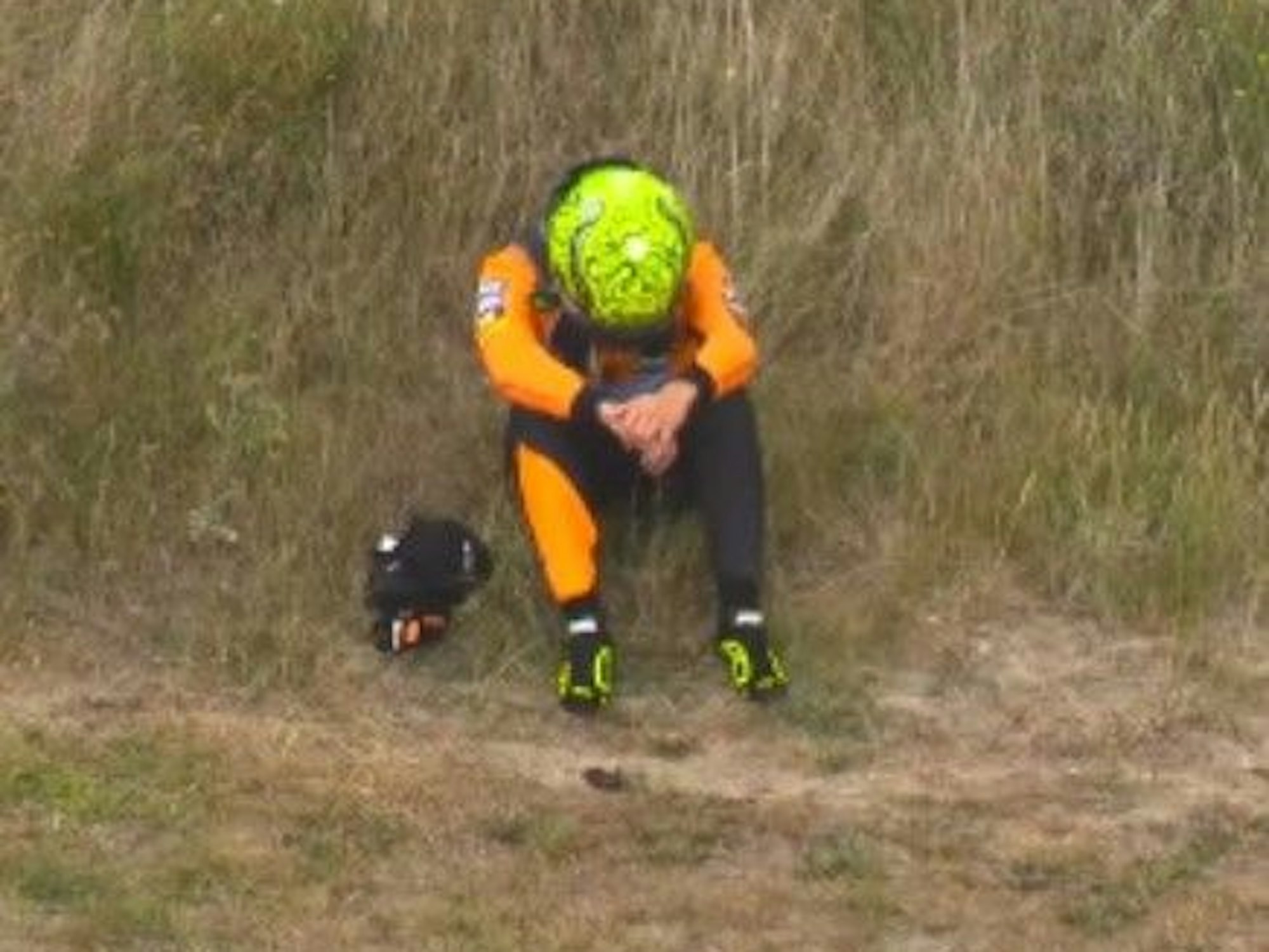 Nach seinem Ausfall sitzt Lando Norris auf einer Düne.