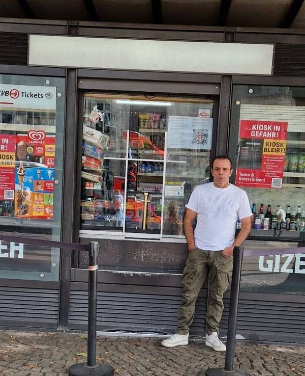 Ein Mann steht vor einem Kiosk.