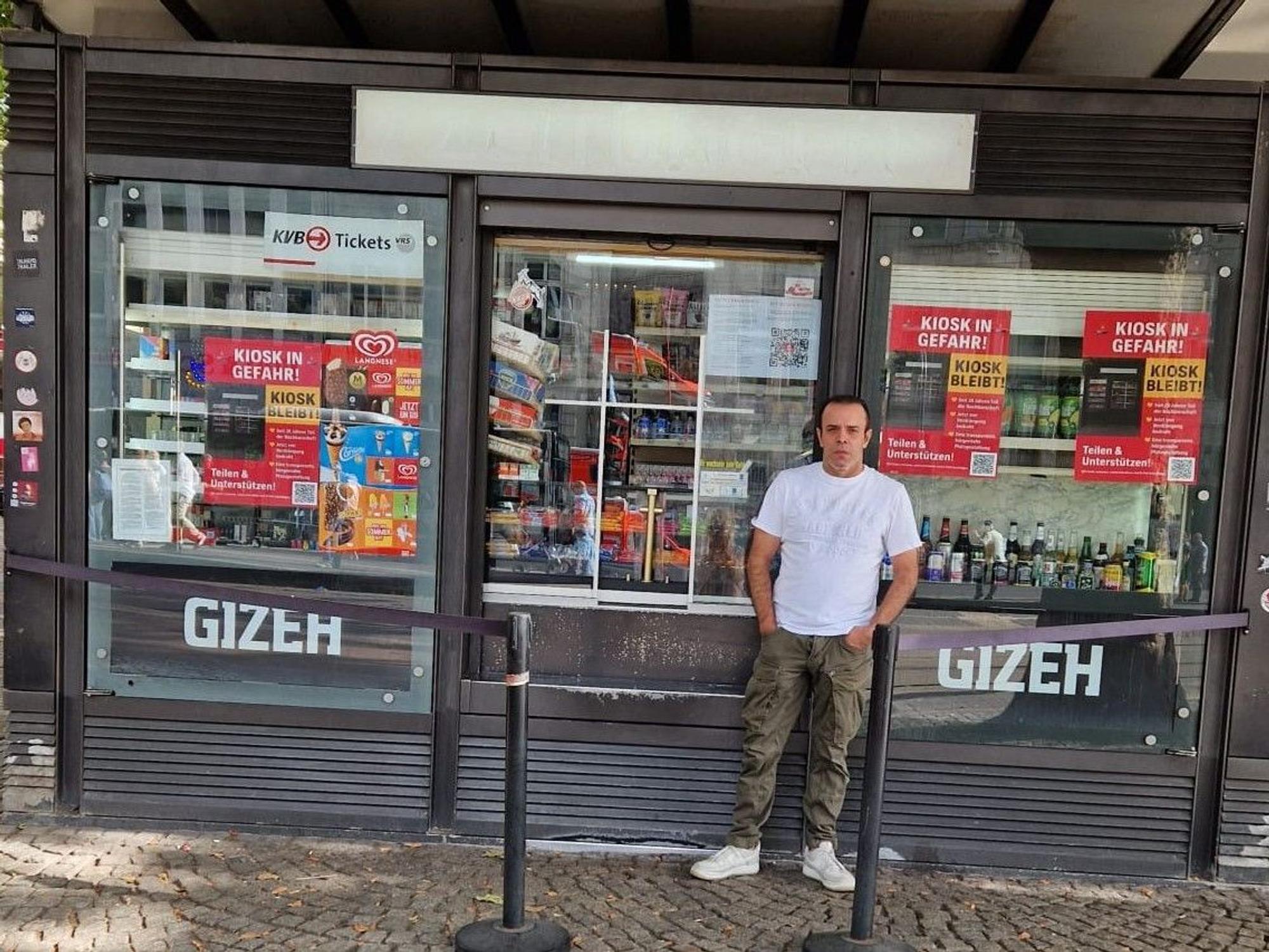 Ein Mann steht vor einem Kiosk.