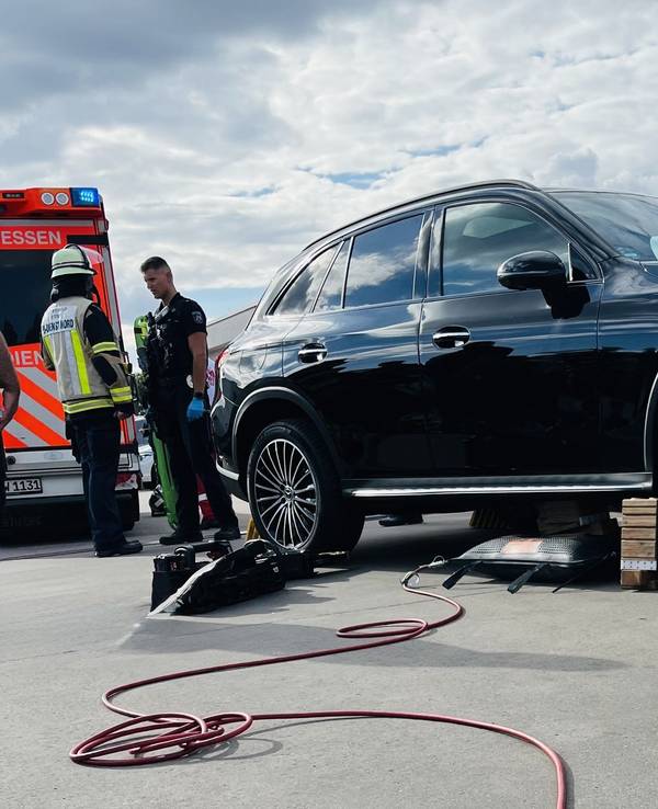 Einsatzkräfte stehen neben einem Auto.