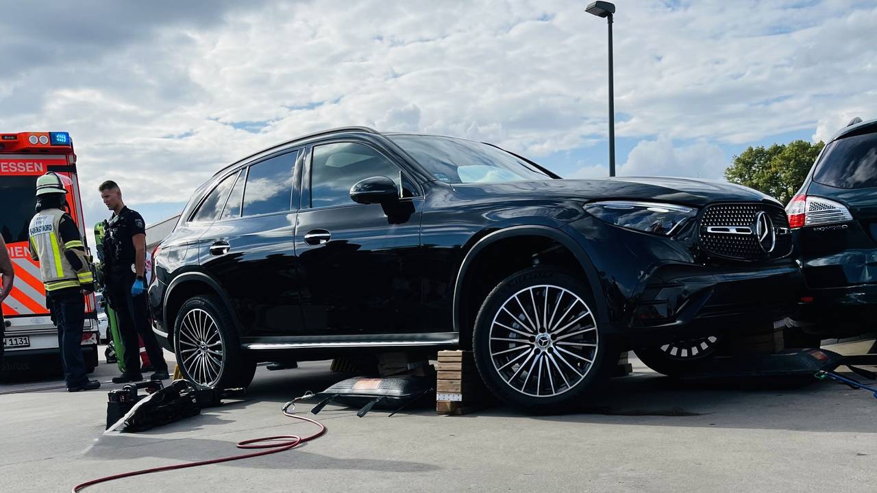 Einsatzkräfte stehen neben einem Auto.