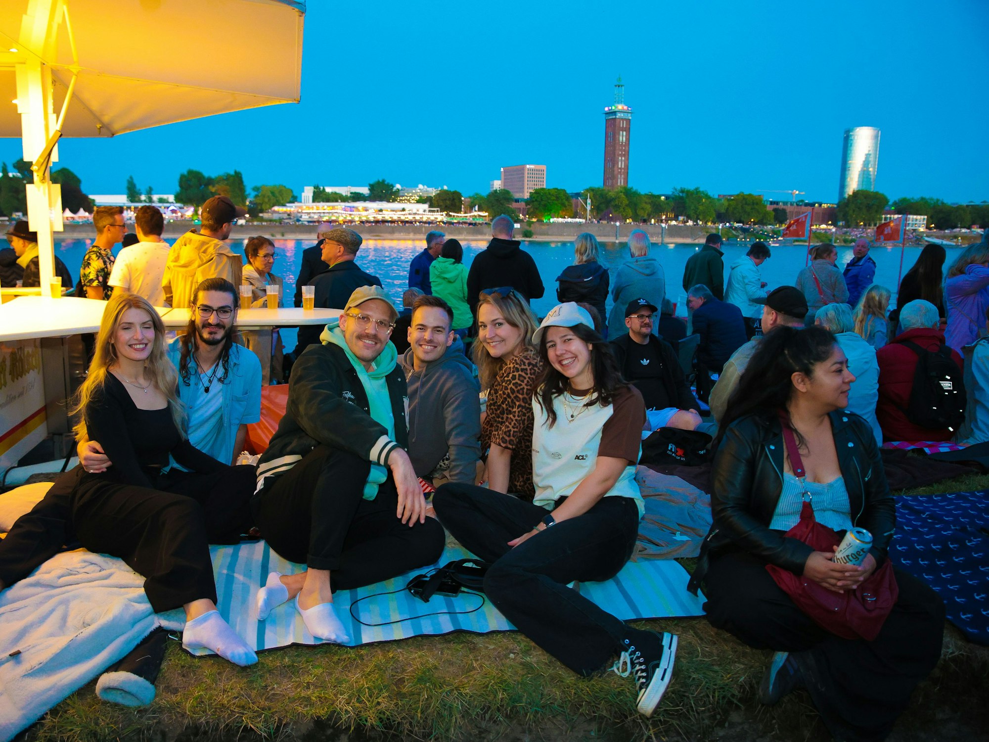 Kölner Lichter: Menschen am Rheinufer vor dem Feuerwerk.