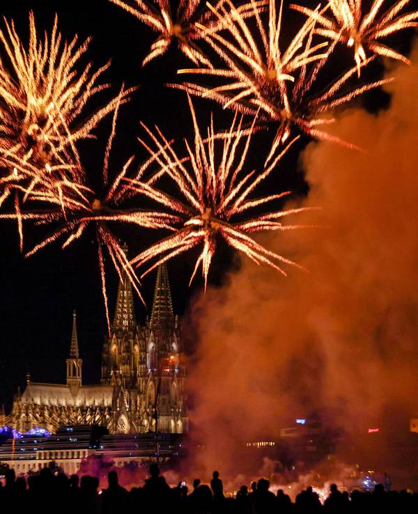 Menschen besuchen im Sommer 2025 im Kölner Rheinpark das größte musiksynchrone Feuerwerk Europas.