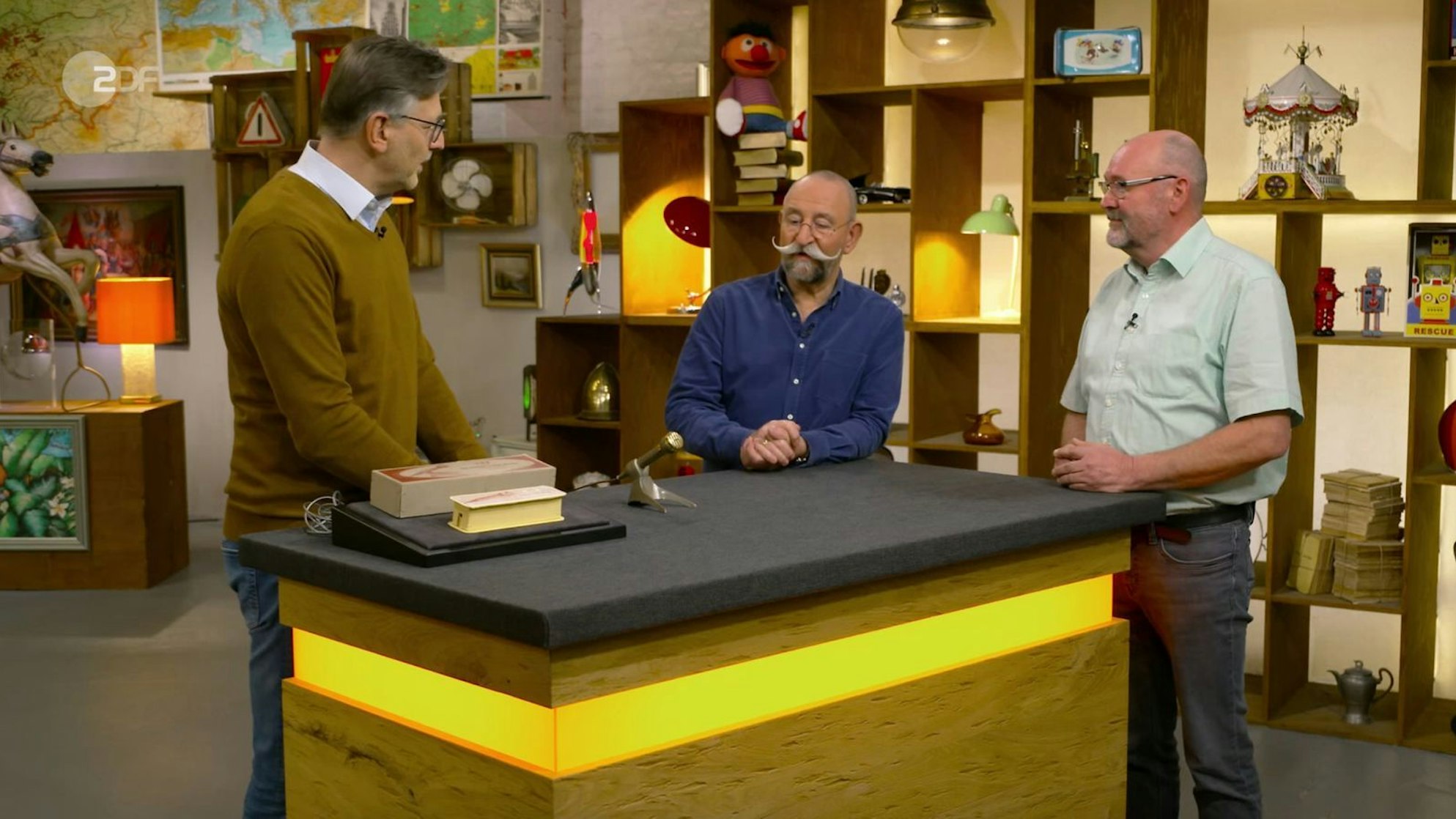 Verkäufer Heiko fragte sich in der Montagsausgabe der ZDF-Trödelshow „Bares für Rares“, ob sein kurioses Objekt „irgendwem noch zu Nutze sein kann“. Horst Lichter jedenfalls fand das Gerät mit Hammerschlaglackierung „geil“ - vor allem nach dem Selbsttest. Auch im Händlerraum kam gleich Schunkelstimmung auf, bis der Kampf um das Mikrofon begann. (Bild: ZDF)