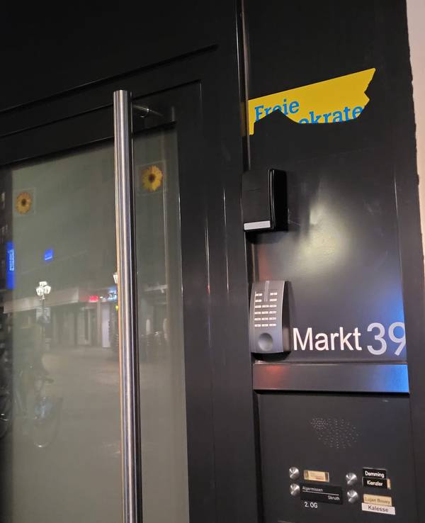 An einer Tür hängt ein abgerissenes Plakat der FDP.
