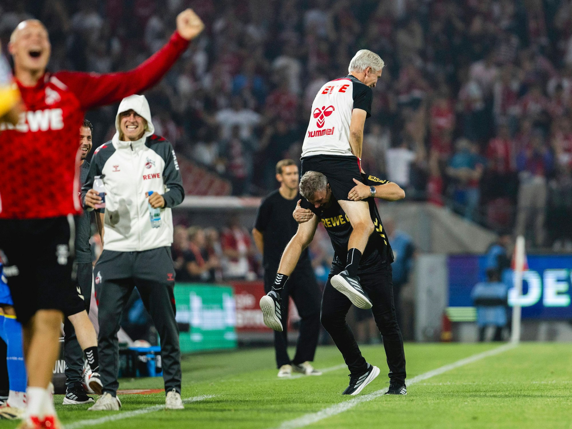 Jubel beim 1. FC Köln: Trainer Lukas Kwasniok trägt Co-Trainer Frank Kaspari durch die Coaching-Zone. Am 31. August 2025 gewann Köln 4:1 gegen den SC Freiburg.