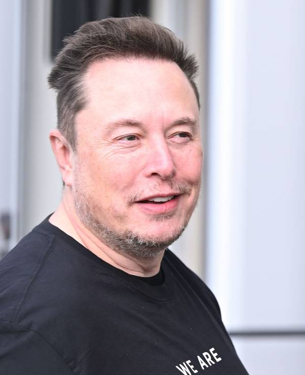 Elon Musk schmunzelt.