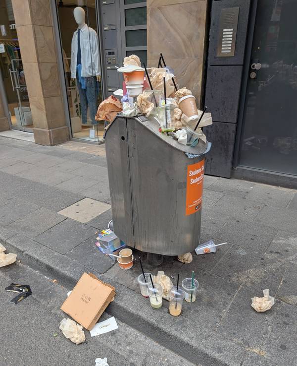 Täglich das gleiche Bild auf der Ehrenstraße. Die Mülleimer sind überfüllt. Getränkebecher und Einwegverpackungen liegen auf dem Gehweg.
