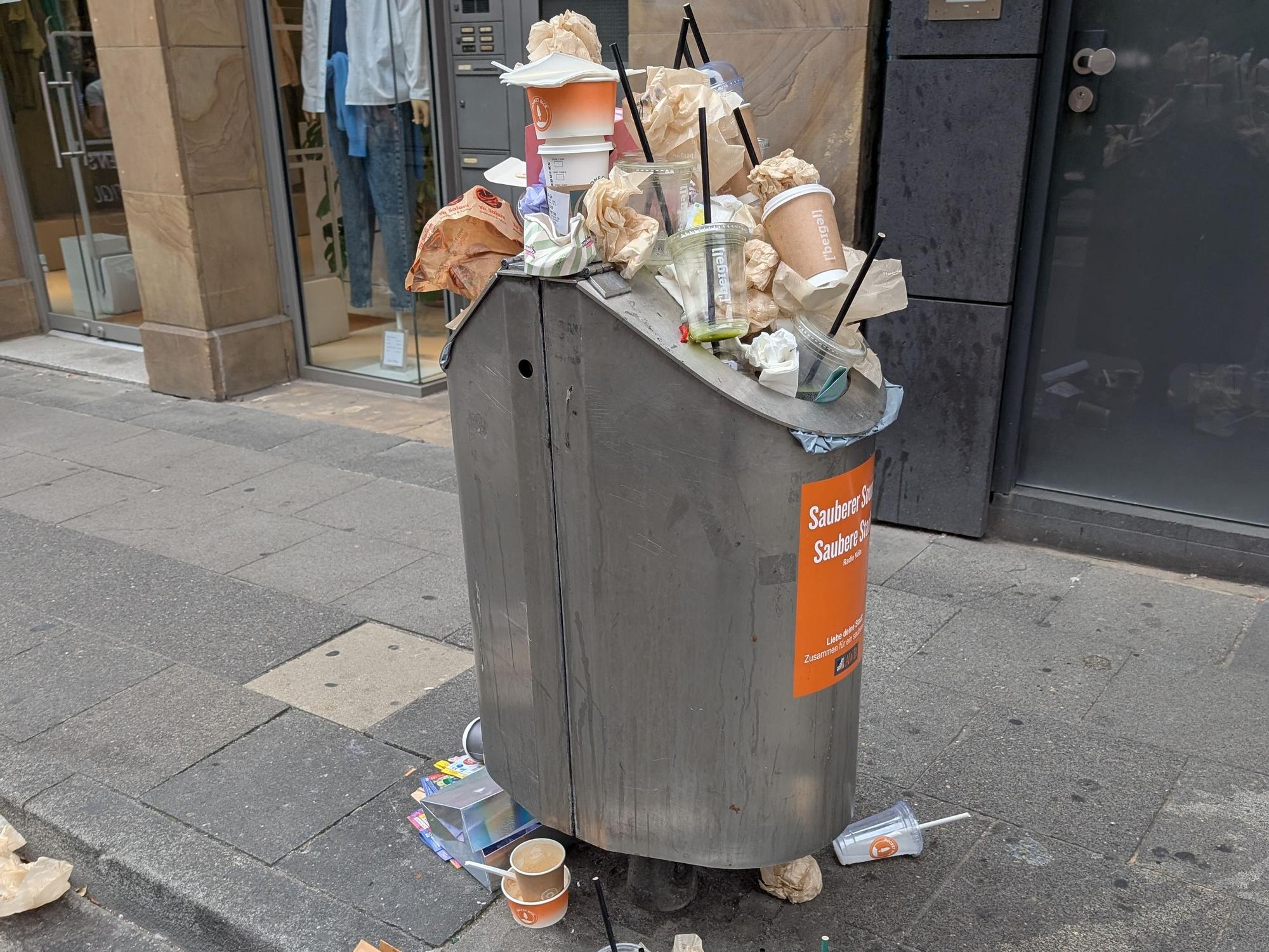 Täglich das gleiche Bild auf der Ehrenstraße. Die Mülleimer sind überfüllt. Getränkebecher und Einwegverpackungen liegen auf dem Gehweg.
