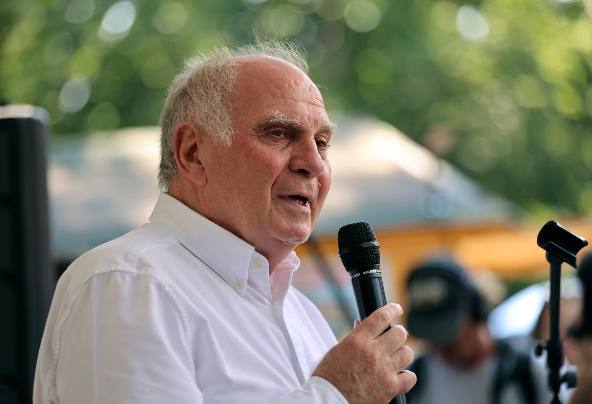 Uli Hoeneß hält ein Mikrofon in der Hand und spricht.