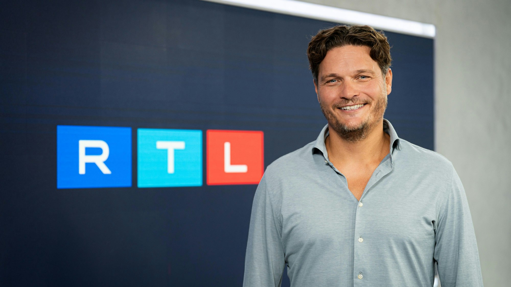 Edin Terzic posiert vor dem RTL-Logo.