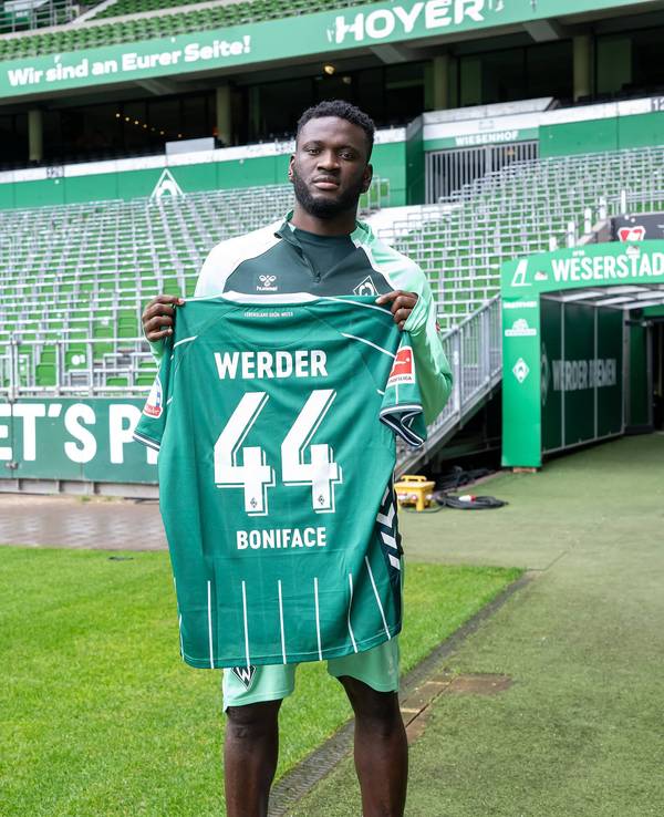 Victor Boniface hält sein neues Trikot vom SV Werder Bremen.