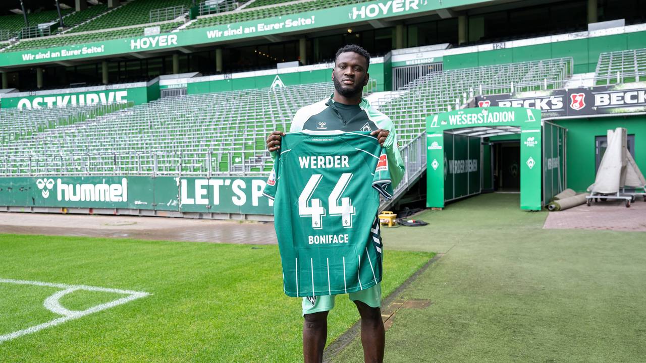 Victor Boniface hält sein neues Trikot vom SV Werder Bremen.