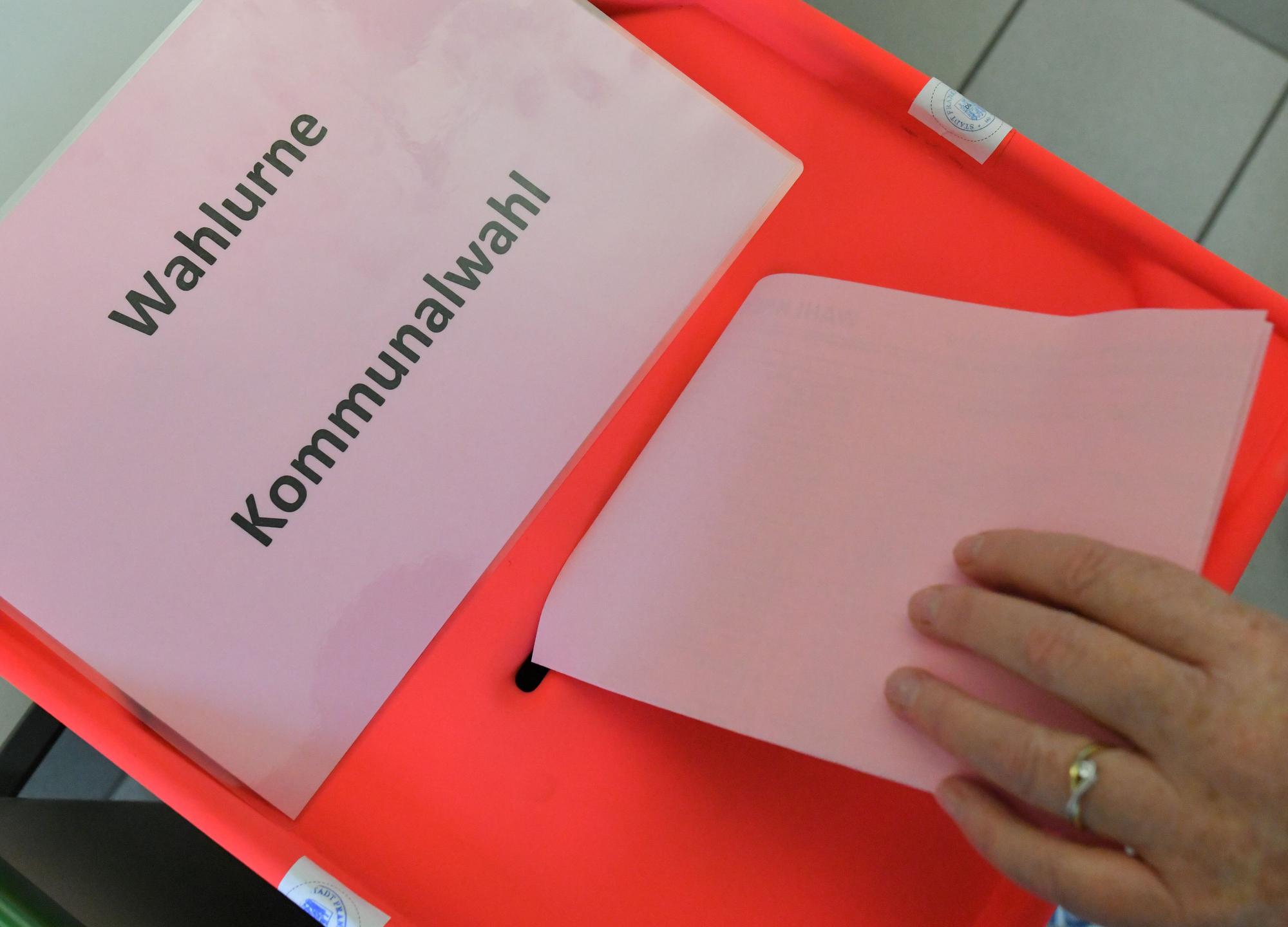 Eine Wählerin steckt ihren Stimmzettel zur Kommunalwahl in Brandenburg in die Wahlurne.
