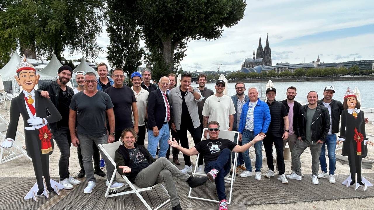 Musiker stehen im Beachclub am Tanzbrunnen zum Gruppenfoto zusammen.