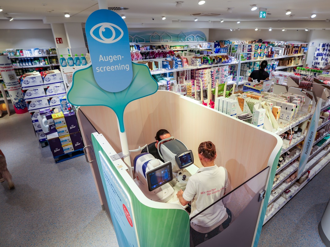 Eine Verkäuferin führt in einer dm-Filiale in Düsseldorf ein Augenscreening bei einem Kunden durch.