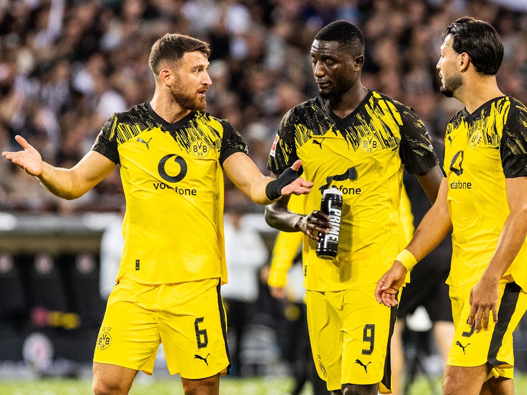 Salih Özcan (l.), Serhou Guirassy (M.) und Ramy Bensebaini sprechen nach dem Spiel miteinander.