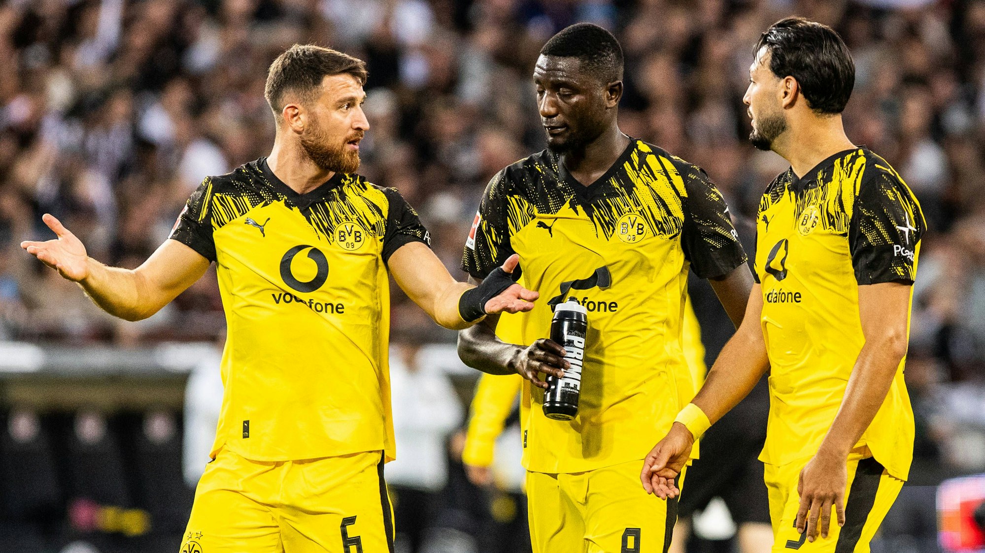 Salih Özcan (l.), Serhou Guirassy (M.) und Ramy Bensebaini sprechen nach dem Spiel miteinander.