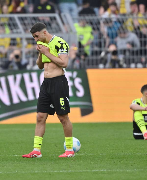 Salih Özcan reibt sich sein Trikot an den Mund.