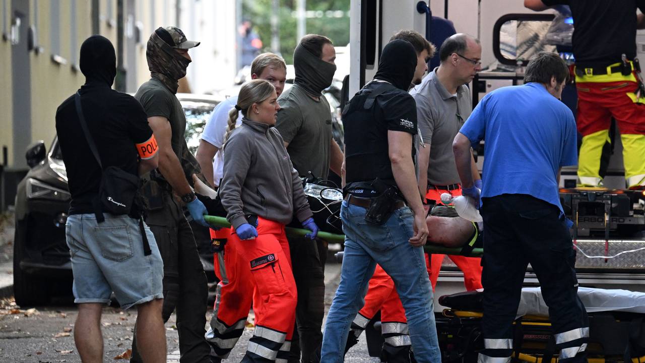 Einsatzkräfte bringen die Trage mit einer verletzten, tatverdächtigen Person zu einem Rettungswagen.