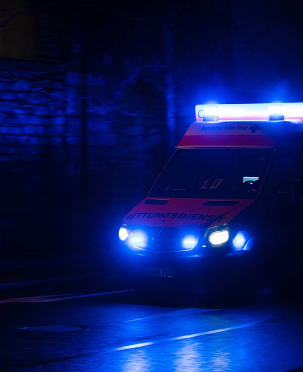 Ein Krankenwagen fährt nachts mit Blaulicht durch eine Straße. (Symbolfoto)