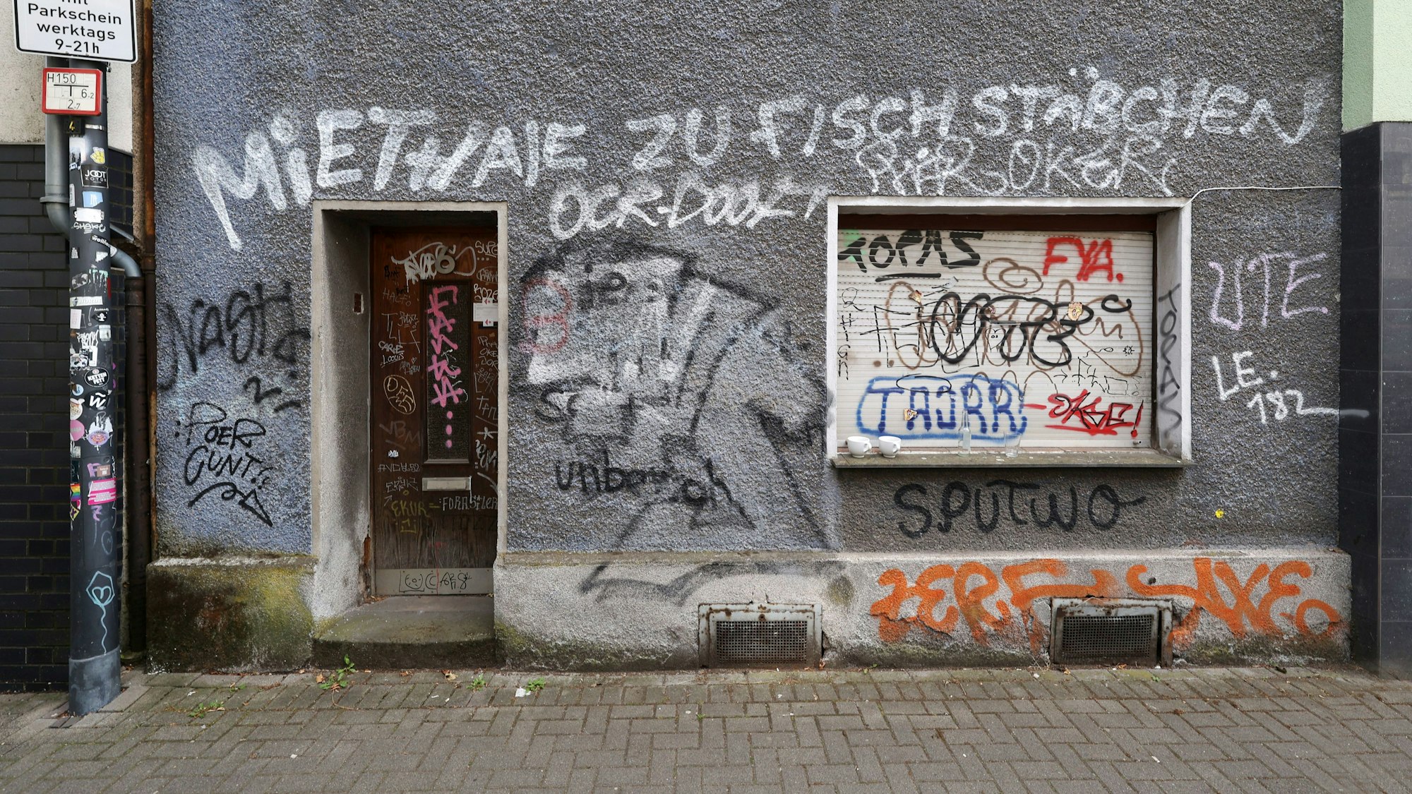 In Ehrenfeld auf der Glasstraße steht an einer Hauswand der Schriftzug „Miethaie zu Fischstäbchen“ (Archivfoto).